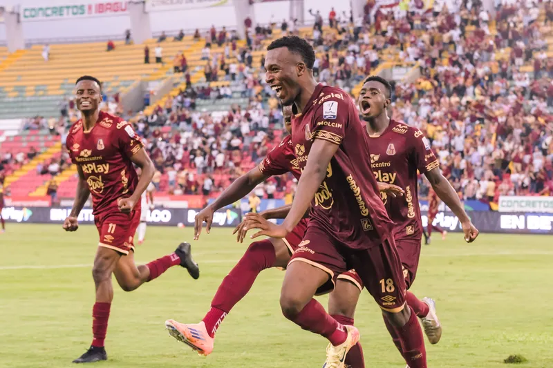 Jugadores celebrando un gol durante un partido de fútbol.