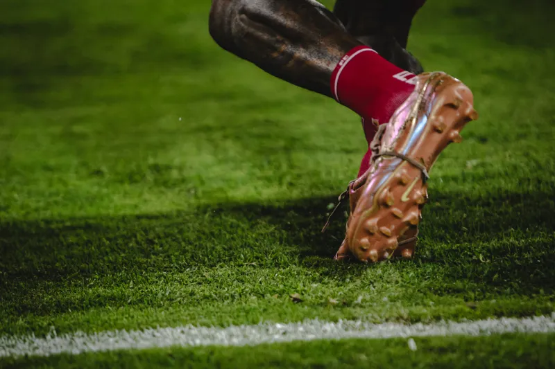 Primer plano de los guayos de un jugador de fútbol.